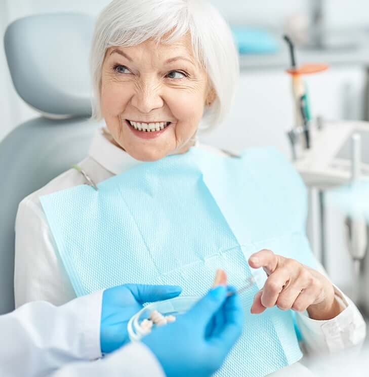 dentist showing a patient a model of what dental implants look like
